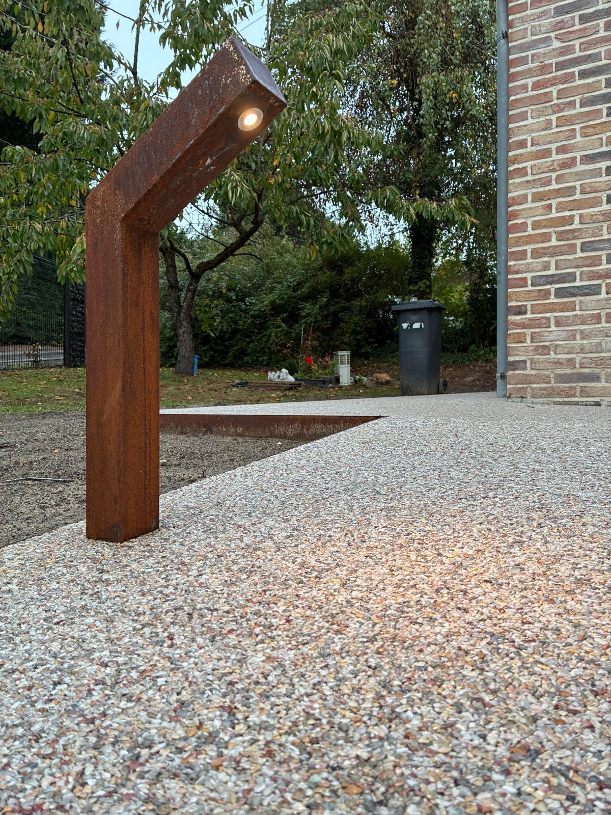 Borne lumineuse en acier Corten sur allée en tapis de pierre